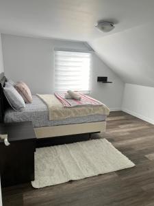 a bedroom with a bed with a window and a rug at Homefeel Stylish Modern House in Chambord