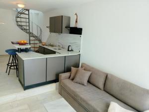a living room with a couch and a kitchen at Phil Samosflats Beachfront Maisonettes in Potokáki