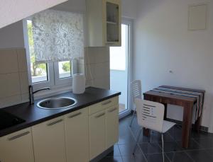 a kitchen with a sink and a table and a window at Apartment 2 Palme in Slatine +23 photos