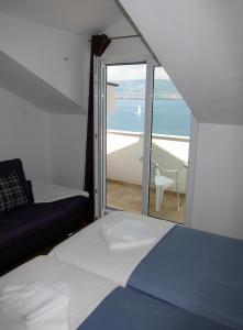 a bedroom with a bed and a view of the ocean at Apartment 2 Palme in Slatine