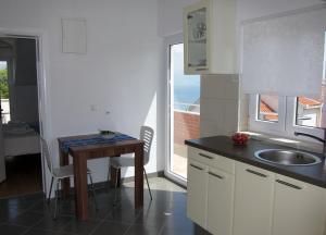 a kitchen with a table and a sink and a window at Apartment 2 Palme in Slatine