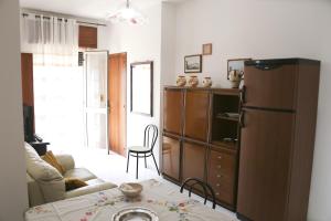 a living room with a table and a refrigerator at Casa Vacanza Teresa con balcone in Torre Mozza