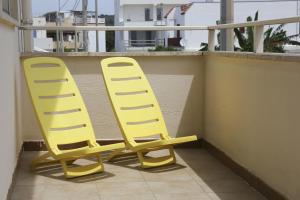two yellow chairs sitting on top of a balcony at Casa Vacanza Teresa con balcone in Torre Mozza