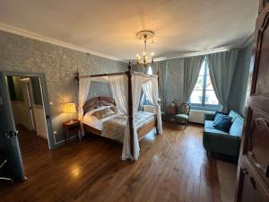 a bedroom with a canopy bed and a couch at Maison de l'Aumance in Meaulne +59 photos