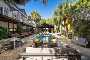 una piscina del resort con tavoli, sedie e palme di Truman Hotel a Key West