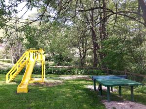 einen Spielplatz mit gelber Rutsche und einem grünen Tisch in der Unterkunft Studiouri Valisoara in Vălişoara