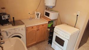 a small kitchen with a washer and a microwave at Къща за гости Veranda Raia Поморие in Kamenar