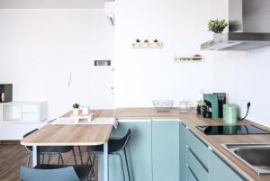 a kitchen with blue cabinets and a wooden table at Asia cozy apartment in Milazzo