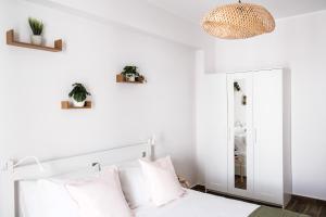 a bedroom with a white bed and a mirror at Asia cozy apartment in Milazzo