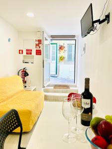 a room with a table with a bottle of wine and glasses at Casa do Mar in Sesimbra
