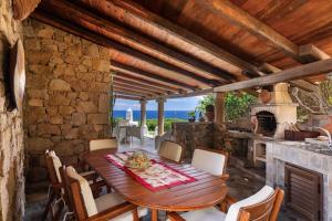 an outdoor dining room with a table and a fireplace at Villa Astra fronte mare - Porto Cervo in Porto Cervo