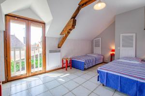 a bedroom with two beds and a balcony at Les grand' vignes in Laines-aux-Bois