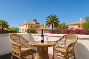 a table with two chairs and a bottle of wine on a balcony at Fantastico 1 - Grossem Balkon - Gratis Parkplatz - Klimaanlage - Zentrumsnähe und Meernähe in Puerto de la Cruz