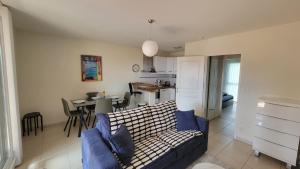 a living room and kitchen with a couch and a table at Résidence Saphir avec piscine et climatisation in Collioure
