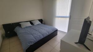 a bedroom with a bed and a flat screen tv at Résidence Saphir avec piscine et climatisation in Collioure