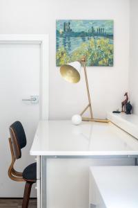 a white desk with a lamp and a painting at Walkable Apt Next to Restaurants, Bars, and Shops! in Portland