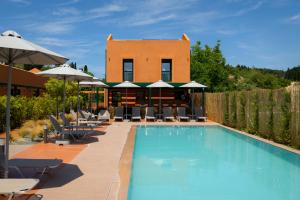 ein Pool in einem Hotel mit Liegestühlen und Sonnenschirmen in der Unterkunft Cape Resort in Peroulades
