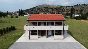 a house with a red roof on top of a field at The River Studio Beli in Podgorica