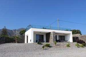 a white house on a hill with mountains in the background at Astrokastro Frangokastello in Frangokastello