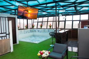 a living room with a tv on a roof at Thalu House in Pacasmayo