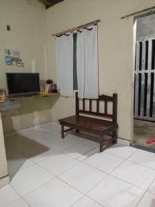 a room with a bench in a room with a tv at Hospedaria lençóis em santo amaro MA in Santo Amaro +17 photos
