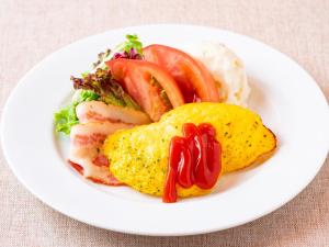 a plate of food with tomatoes and eggs on a table at APA Hotel Akihabara Ekimae in Tokyo