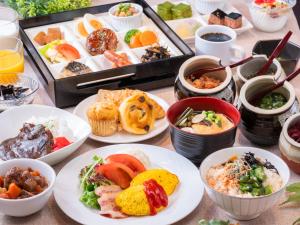 a table topped with plates of food and bowls of food at APA Hotel Akihabara Ekimae in Tokyo
