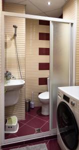a bathroom with a toilet and a washing machine at Central Park Apartment in Veliko Tŭrnovo