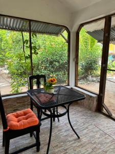 Ein Tisch und zwei Stühle auf einer Veranda mit einem Tisch und zwei Fenstern in der Unterkunft Cabañas santamaria in Tulum