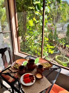 ein Tisch mit zwei Tellern Essen darauf und einem Fenster in der Unterkunft Cabañas santamaria in Tulum