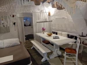 een kamer met een witte tafel en een bank bij Villa Romantica in Parikia