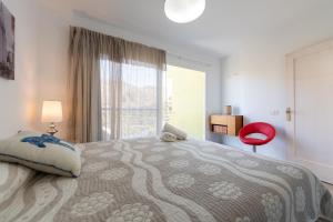 sypialnia z łóżkiem i oknem z czerwonym krzesłem w obiekcie Finca Oasis Holidays & Health - Charming Villas w mieście Balcon de Telde +37 zdjęć