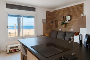 a kitchen and living room with a view of the ocean at La Bellamar - Apartamento en primera línea mar- in Premiá de Mar
