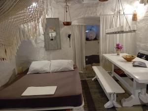 een kamer met een bed, een tafel en een bureau bij Villa Romantica in Parikia