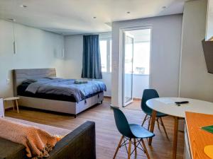 a bedroom with a bed and a table and chairs at Athens Pearl in Athens