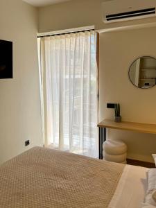 a bedroom with a bed and a large window at Yria Hotel in Zakynthos Town
