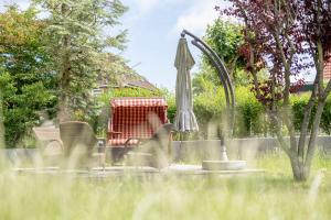a garden with an umbrella and a chair and a sink at ELSE in der 'Stranddistel' in Langeoog