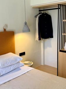 a bedroom with a bed and a rack with clothes at Yria Hotel in Zakynthos Town
