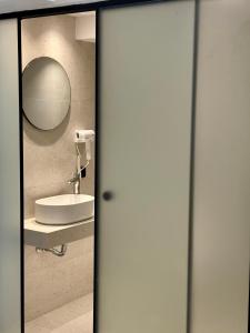 a bathroom with a sink and a mirror at Yria Hotel in Zakynthos Town