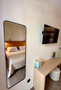 a mirror in a bedroom with a bed and a desk at Yria Hotel in Zakynthos Town