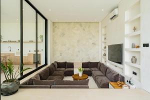 a living room with a couch and a tv at Brandnew 4BR Luxury Estate next to Beach & views in Cemagi