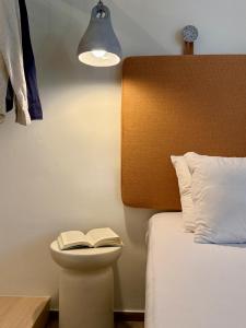 a bedroom with a bed and a book on a night stand at Yria Hotel in Zakynthos Town