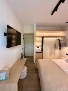 a bedroom with a bed and a tv on a wall at Yria Hotel in Zakynthos Town