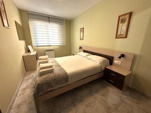 a bedroom with a large bed and a window at Apartamento Welcome Grañamar in Sanxenxo +15 photos