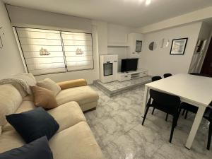 a living room with a couch and a table at Apartamento Welcome Grañamar in Sanxenxo
