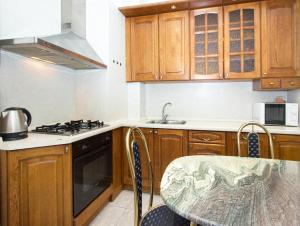 a kitchen with wooden cabinets and a stove top oven at ApartLux Park Pobedy in Moscow