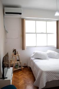 a bedroom with a bed and a window at Apto Centro do Rio - Cinelândia - Consulado Americano - Vivo Rio - 1 min Metrô in Rio de Janeiro