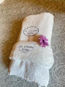 een handdoek met een paarse bloem erop bij Le Villette Luisa in Lampedusa