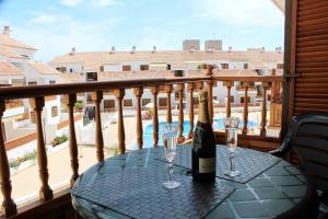 una mesa con 2 copas y una botella de vino en el balcón en House El Cardon by Holiday World, en Playa de las Américas
