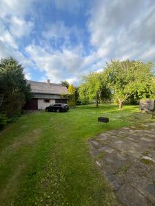 une cour avec une voiture garée devant une maison dans l'établissement Pušų Sodas, à Birštonas
